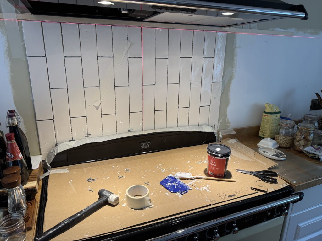 Tiling the splashback in ripple effect cream vertical metro tiles with biscuit coloured grouting